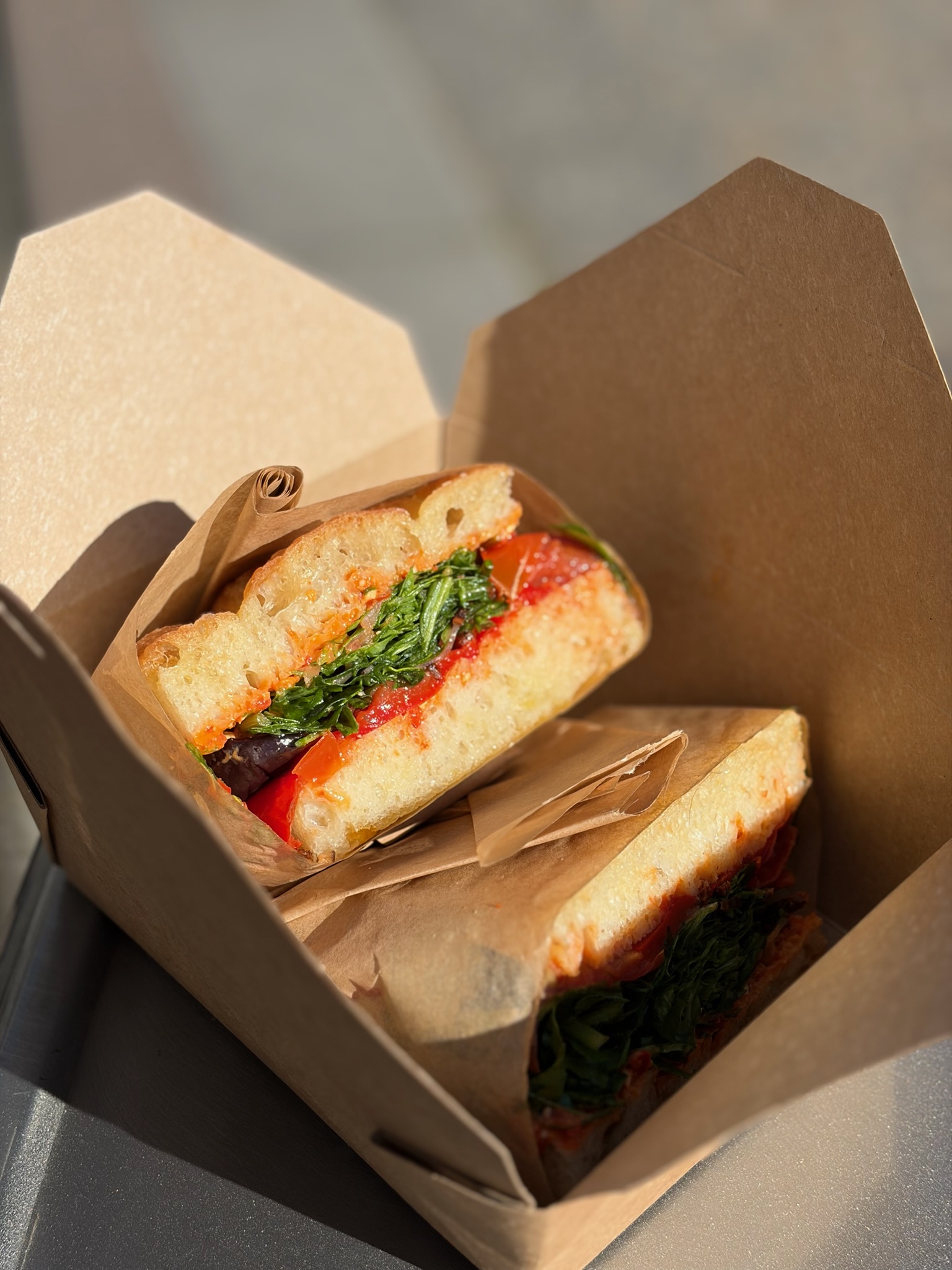 A focaccia sandwich in a kraft box on a sunlit counter at Glasthule.