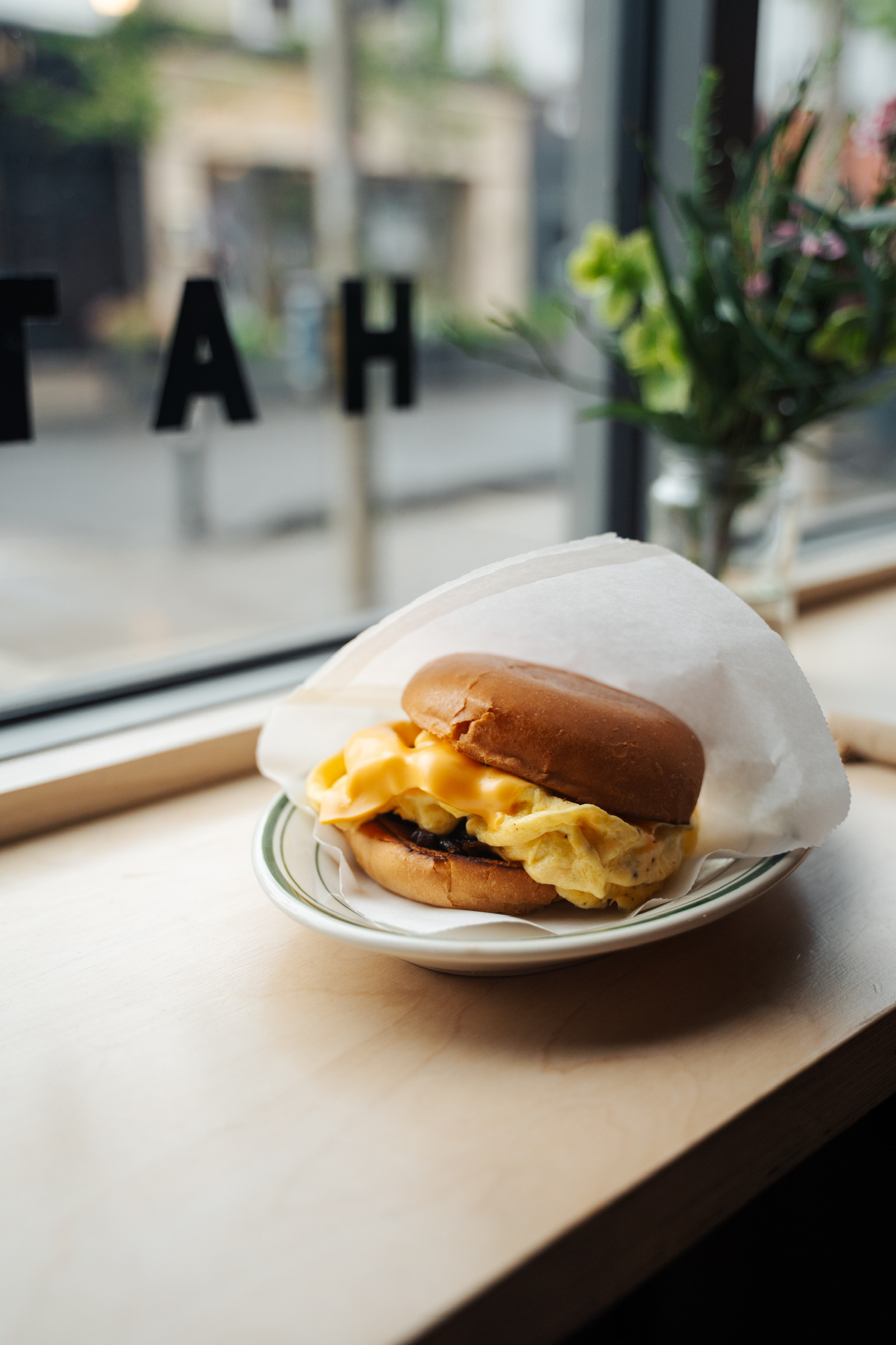 A breakfast bap on the window counter at Blackrock, the HATCH decal read from inside.